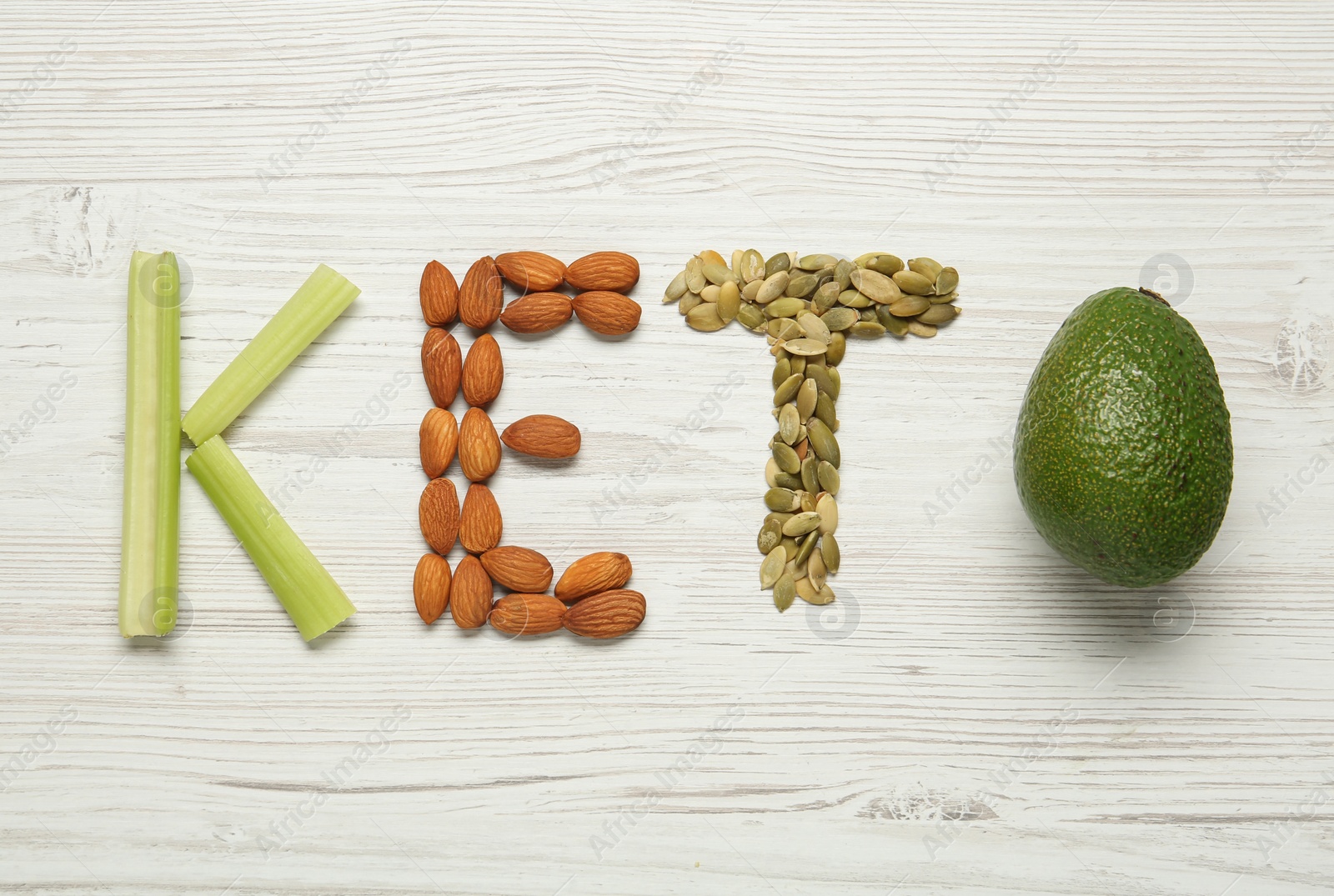 Photo of Word Keto made with different products on white wooden table, flat lay