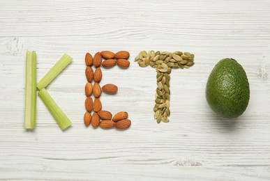 Word Keto made with different products on white wooden table, flat lay