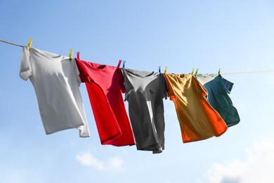 Clothes hanging on washing line against sky