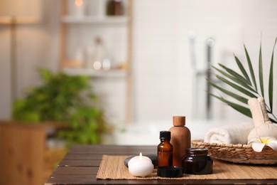 Photo of Composition with different spa products on wooden table in bathroom, space for text