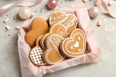 Photo of Tasty heart shaped gingerbread cookies and festive decor on light table