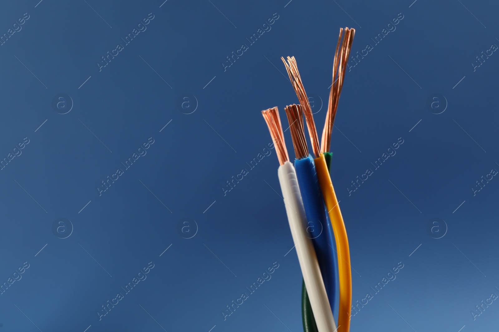 Photo of Closeup view of electrical power cables on blue background, space for text