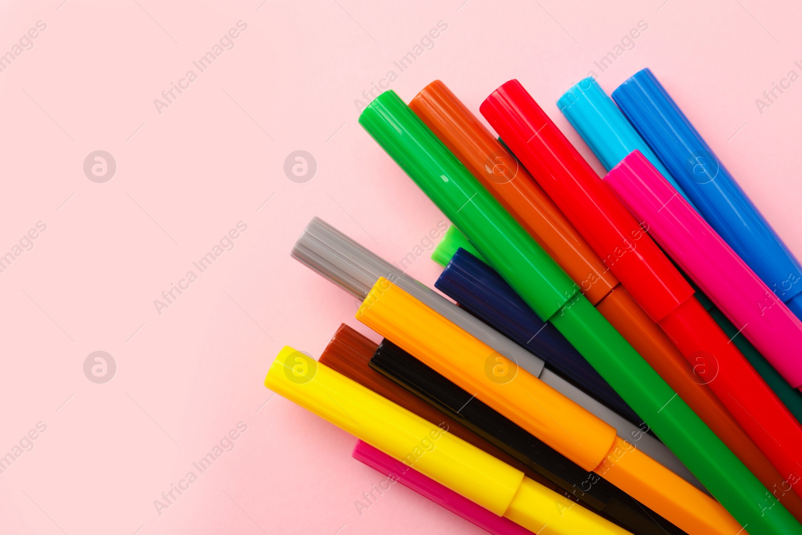 Photo of Many bright markers on pink background, flat lay. Space for text