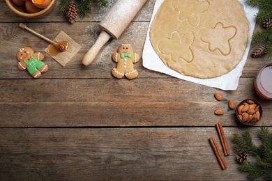 Flat lay composition with homemade gingerbread man cookies on wooden table, space for text