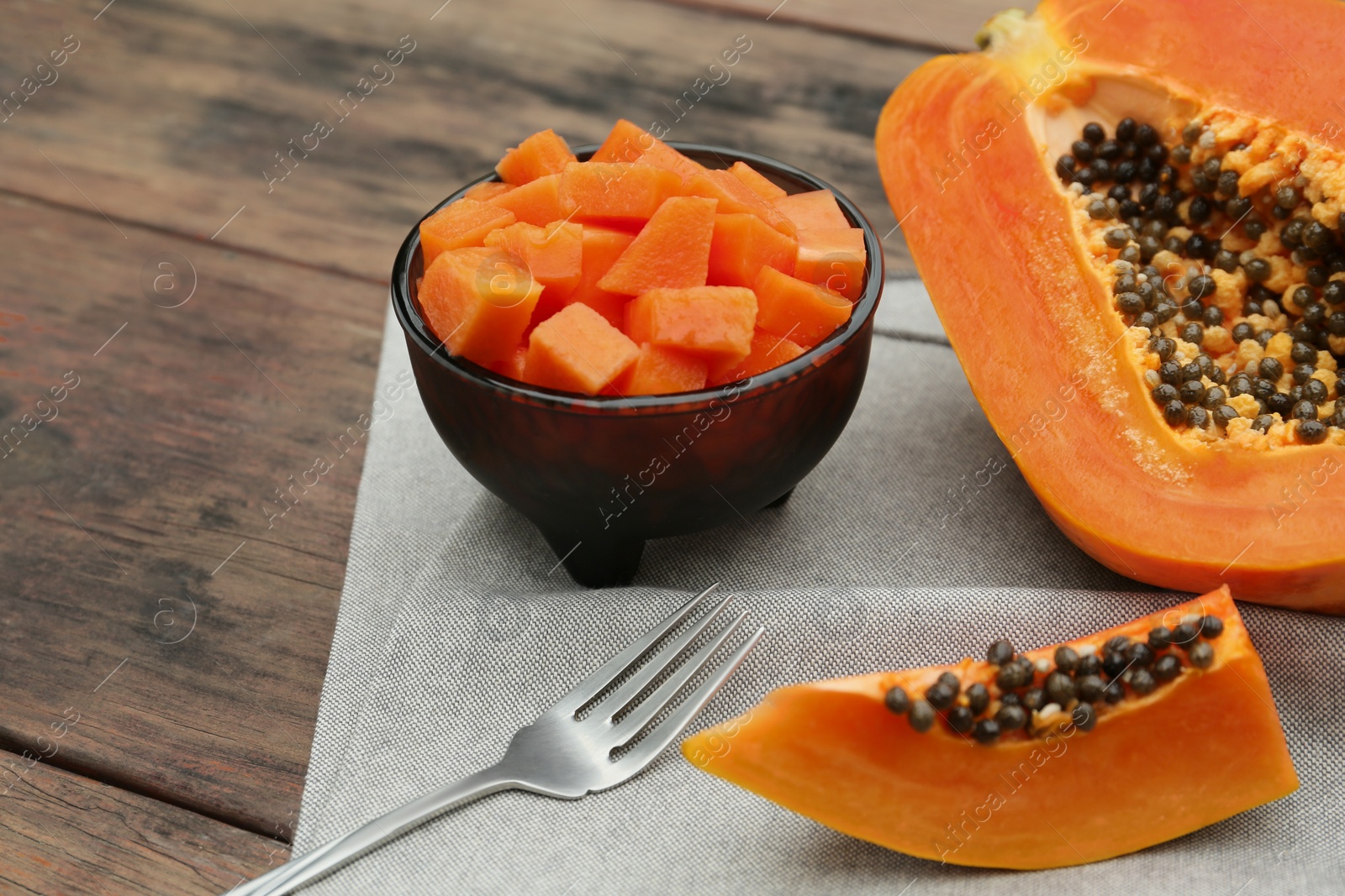 Photo of Tasty cut papaya fruits on wooden table