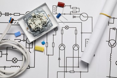 Photo of Wires and disassembled light switch on wiring diagrams, top view