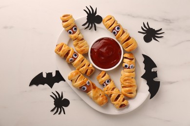 Photo of Flat lay composition with tasty sausage mummies for Halloween party on white marble table