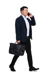 Businessman in suit with briefcase walking on white background