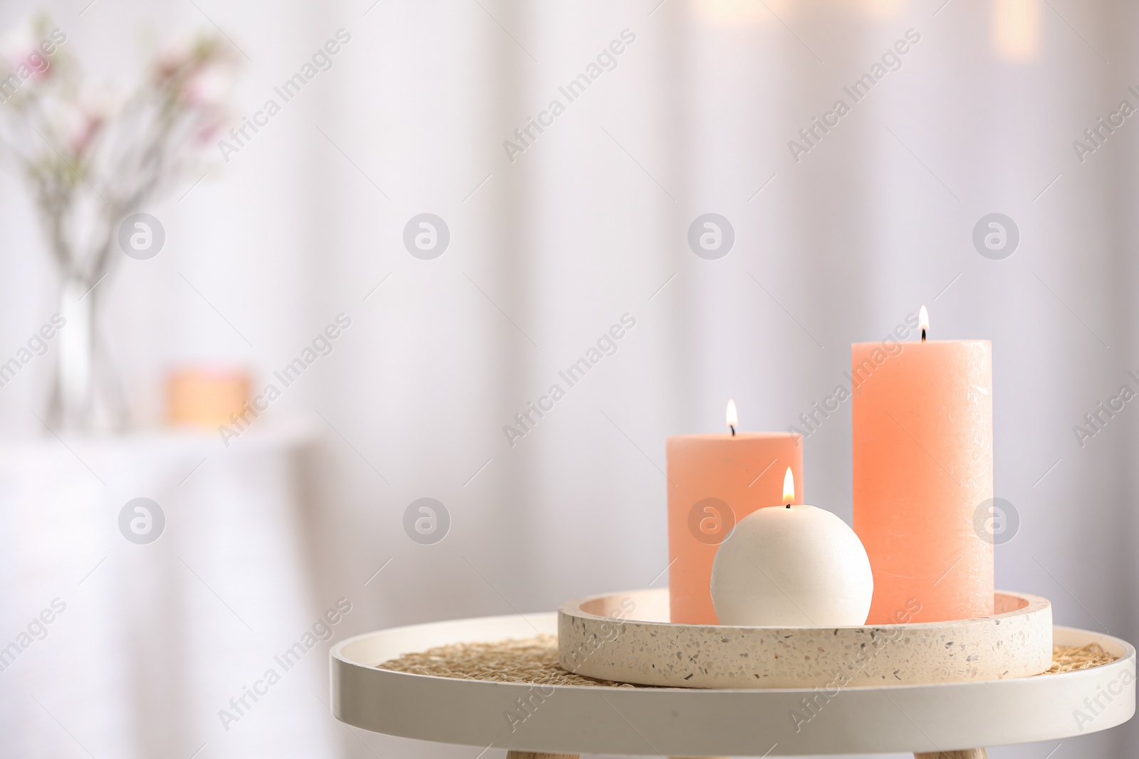 Photo of Burning candles on table indoors. Space for text