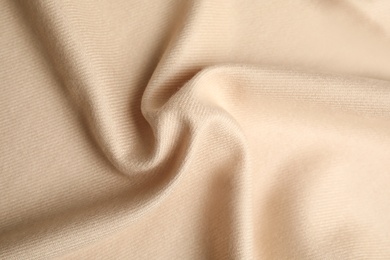 Photo of Beige soft cashmere fabric as background, closeup