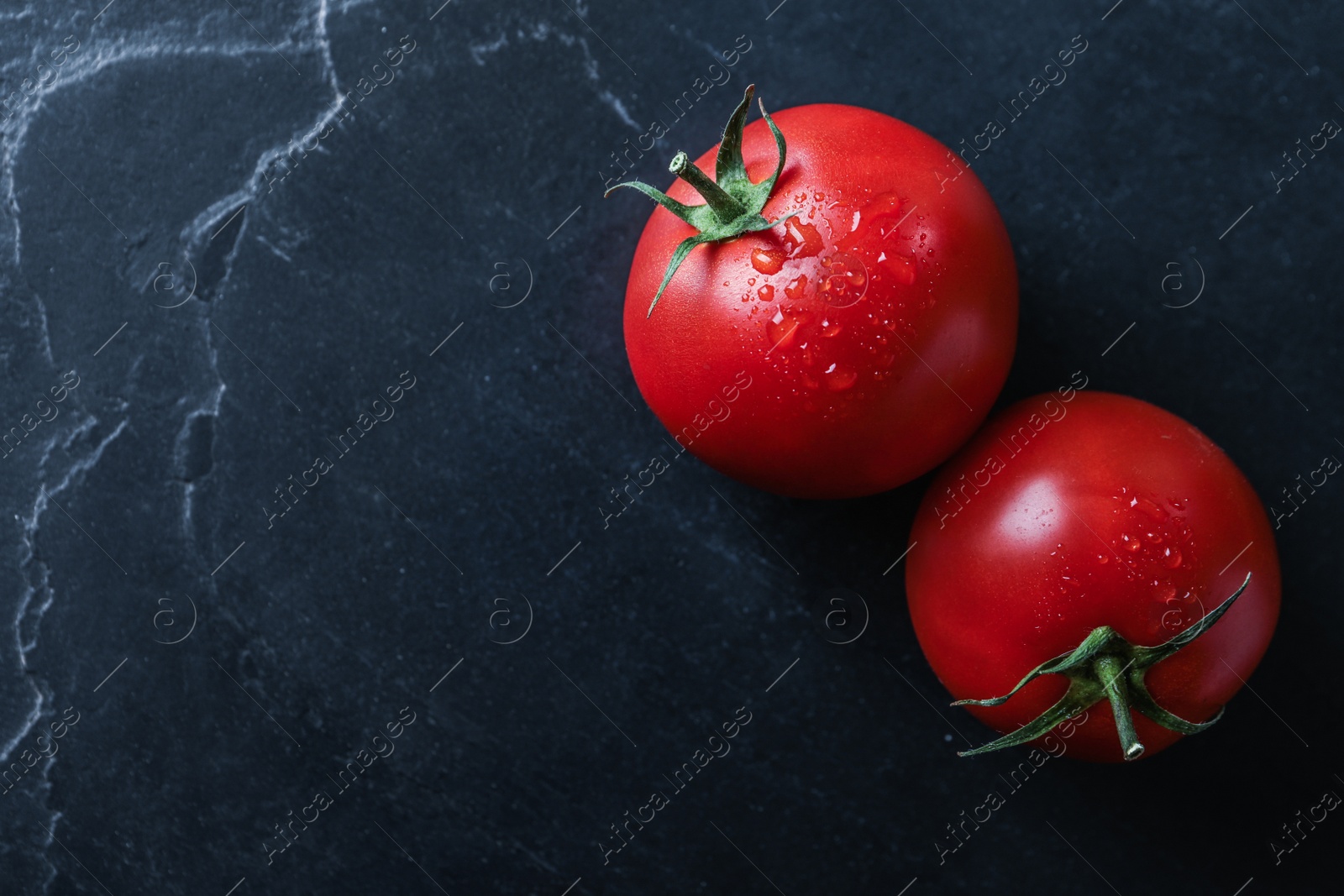 Photo of Fresh ripe tomatoes on black table, flat lay. Space for text