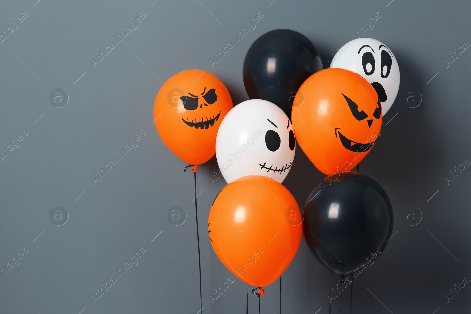 Photo of Color balloons for Halloween party on gray background. Space for text