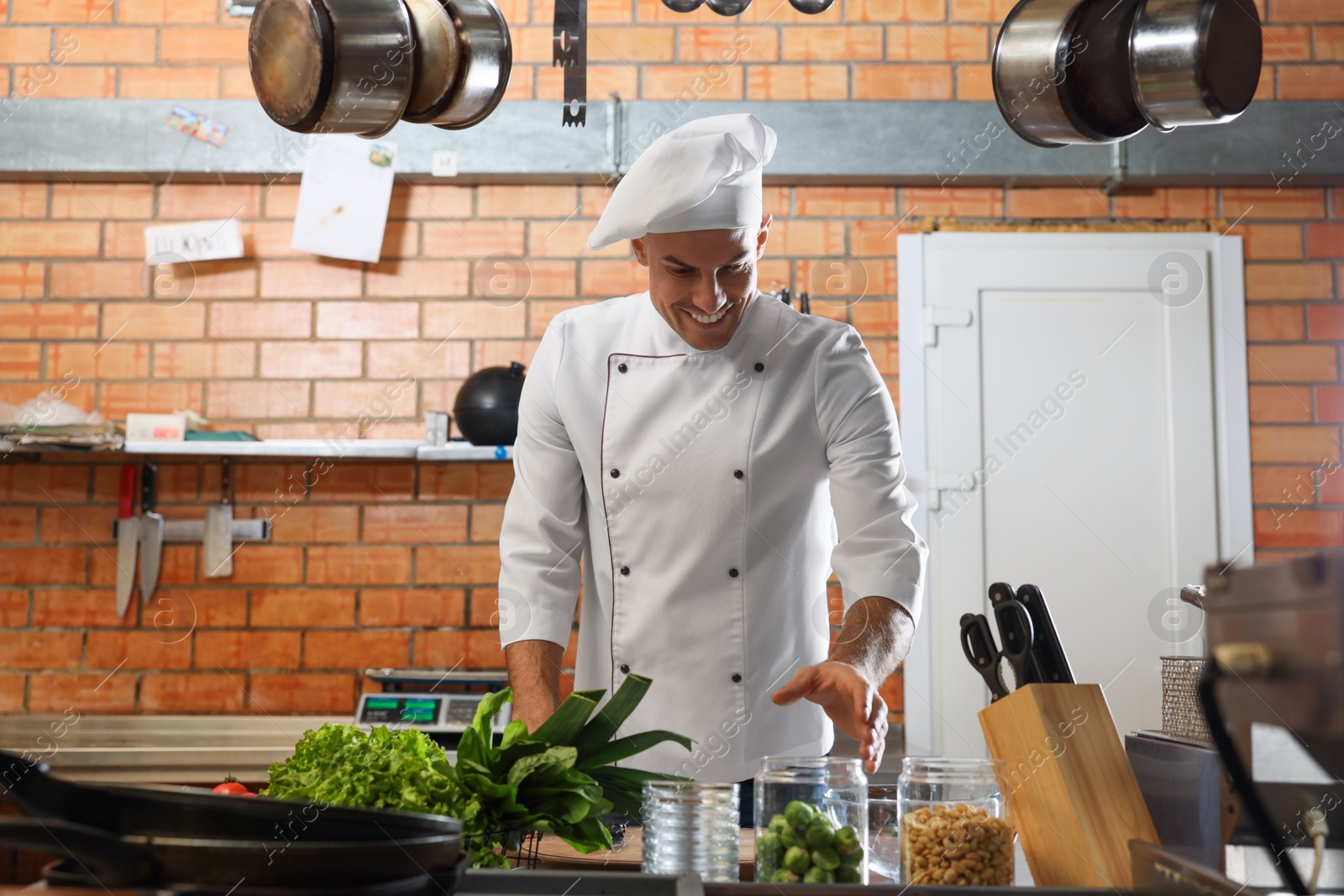 Photo of Professional chef cooking vegetables in restaurant kitchen