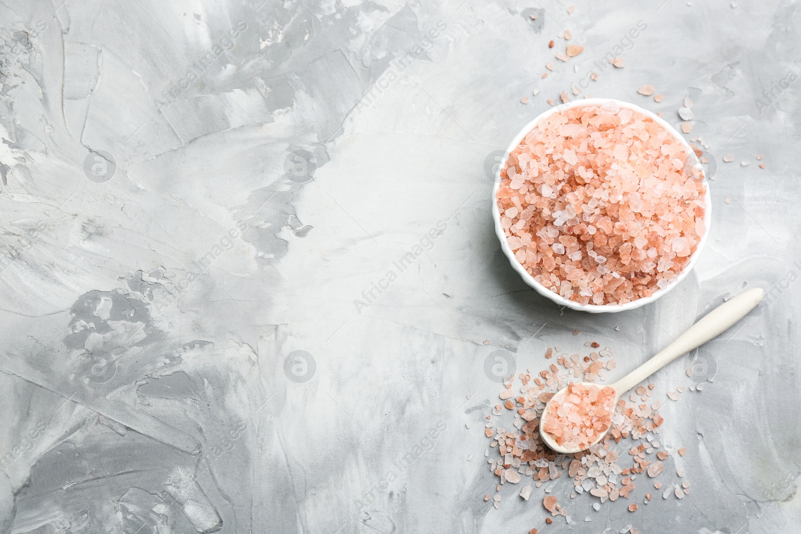 Photo of Pink himalayan salt on grey table, flat lay. Space for text