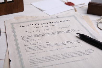 Photo of Last will and testament with pen on white wooden table, closeup