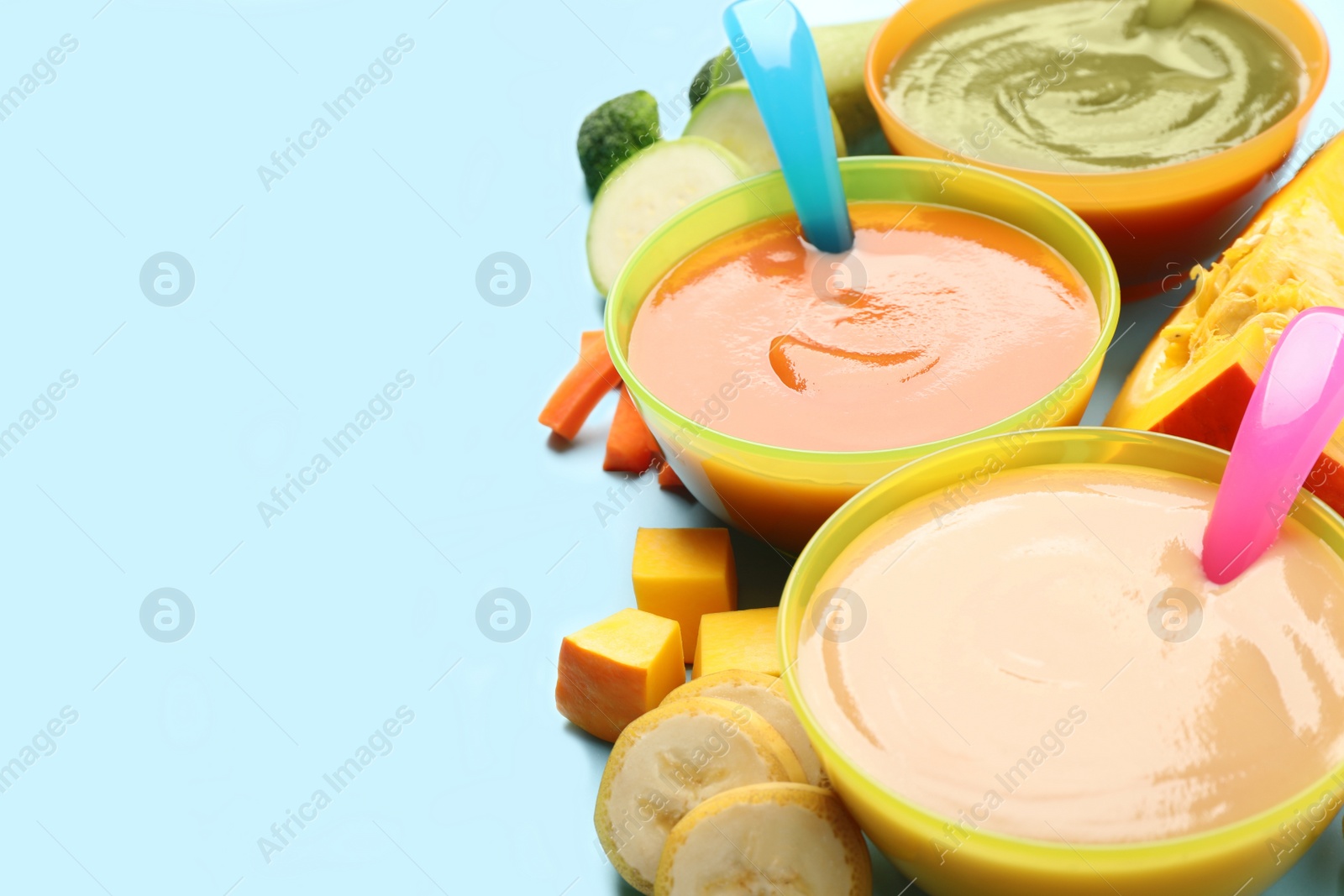 Photo of Healthy baby food and fresh ingredients on light blue background, closeup. Space for text