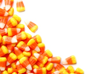 Photo of Colorful candy corns for Halloween party on white background, top view