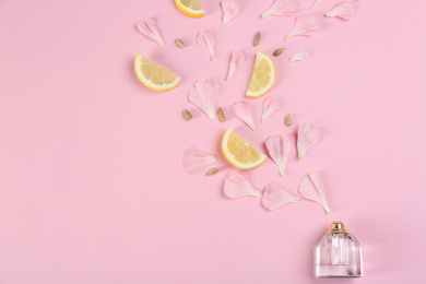 Photo of Flat lay composition with bottle of perfume on pink background, space for text