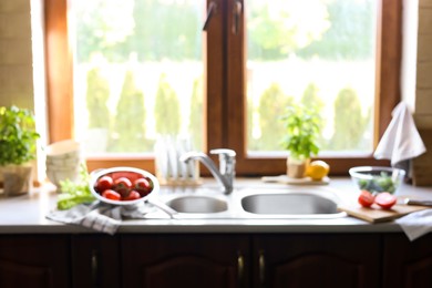 Photo of Blurred view of stylish kitchen interior with sink and products