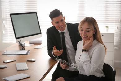 Photo of Man flirting with his colleague during work in office