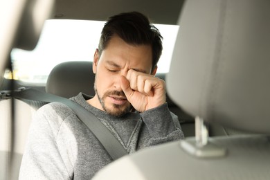 Sleepy tired man sitting in modern car