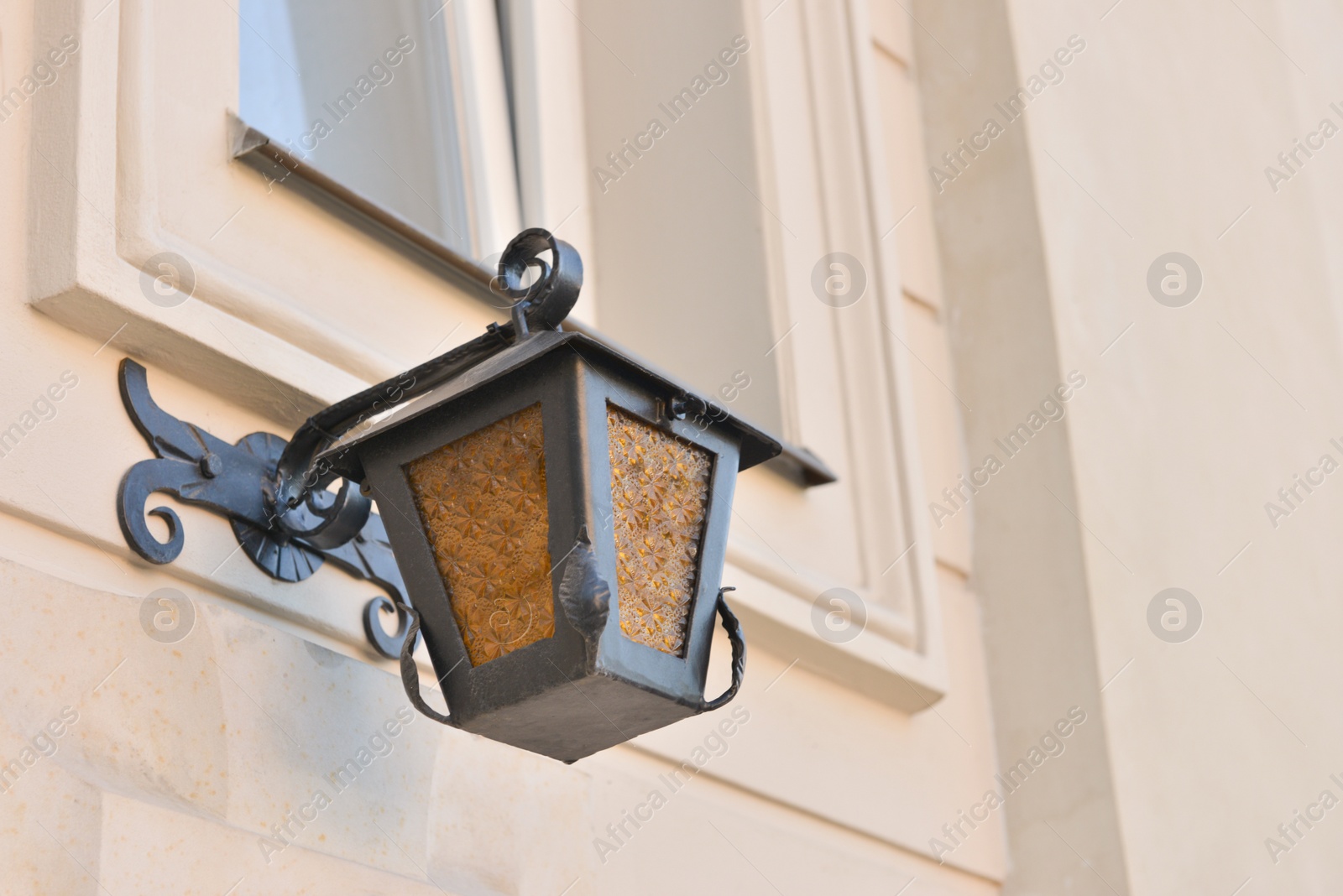 Photo of Beautiful vintage street lamp hanging on wall of building