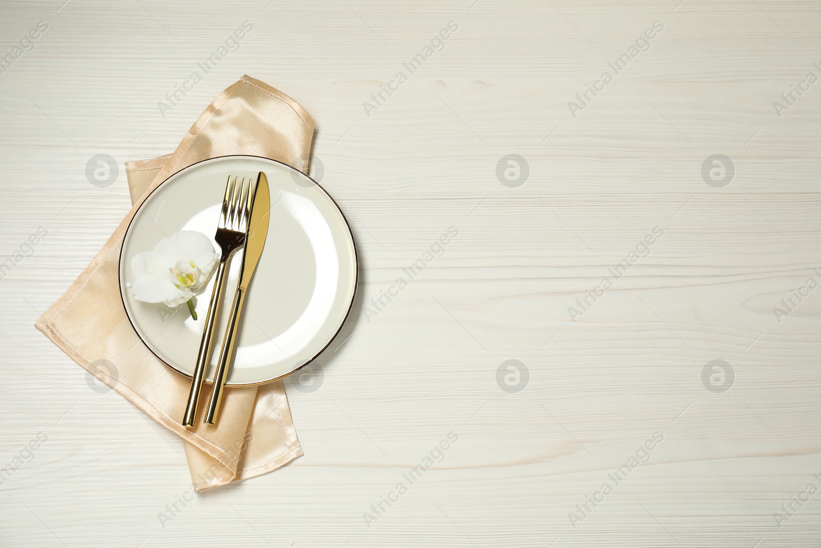 Photo of Stylish setting with elegant cutlery on white wooden table, top view. Space for text