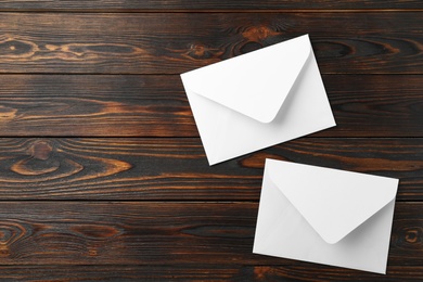 White paper envelopes on wooden background, flat lay. Space for text