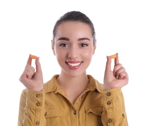 Young woman with foam ear plugs on white background