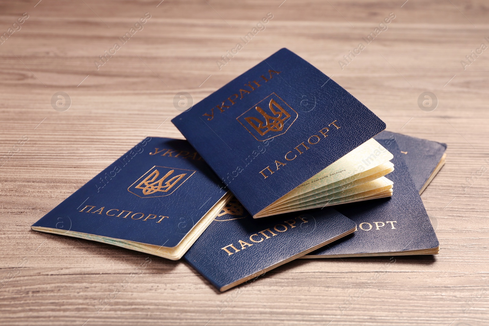 Photo of Many Ukrainian internal passports on wooden background