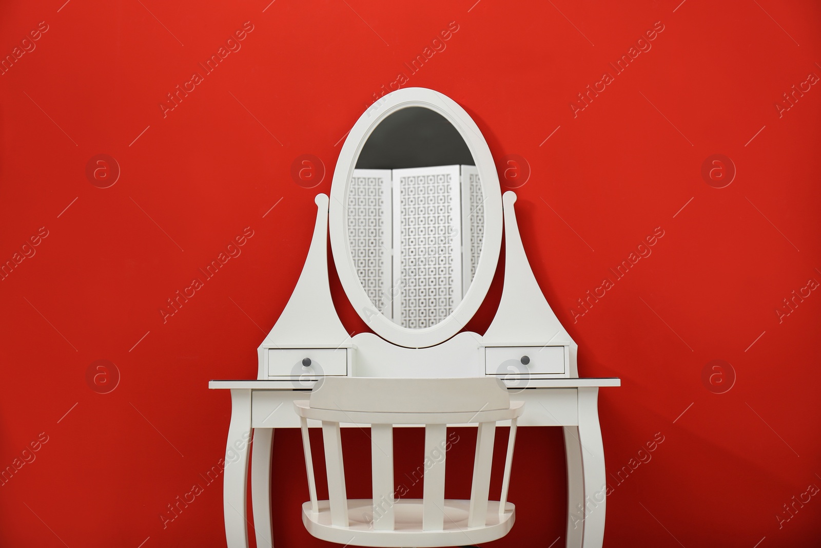 Photo of Elegant white makeup table and chair on red background