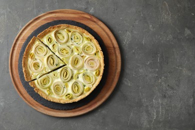 Photo of Tasty leek pie on dark textured table, top view. Space for text