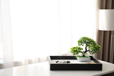 Photo of Beautiful miniature zen garden on white table indoors