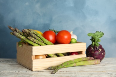 Photo of Wooden crate with fresh ripe vegetables on table. Organic food