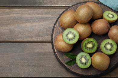 Photo of Fresh ripe kiwis on wooden table, top view. Space for text