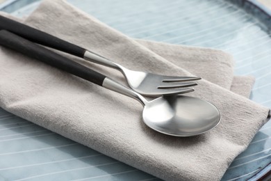 Stylish setting with cutlery, napkin and plate on table, closeup