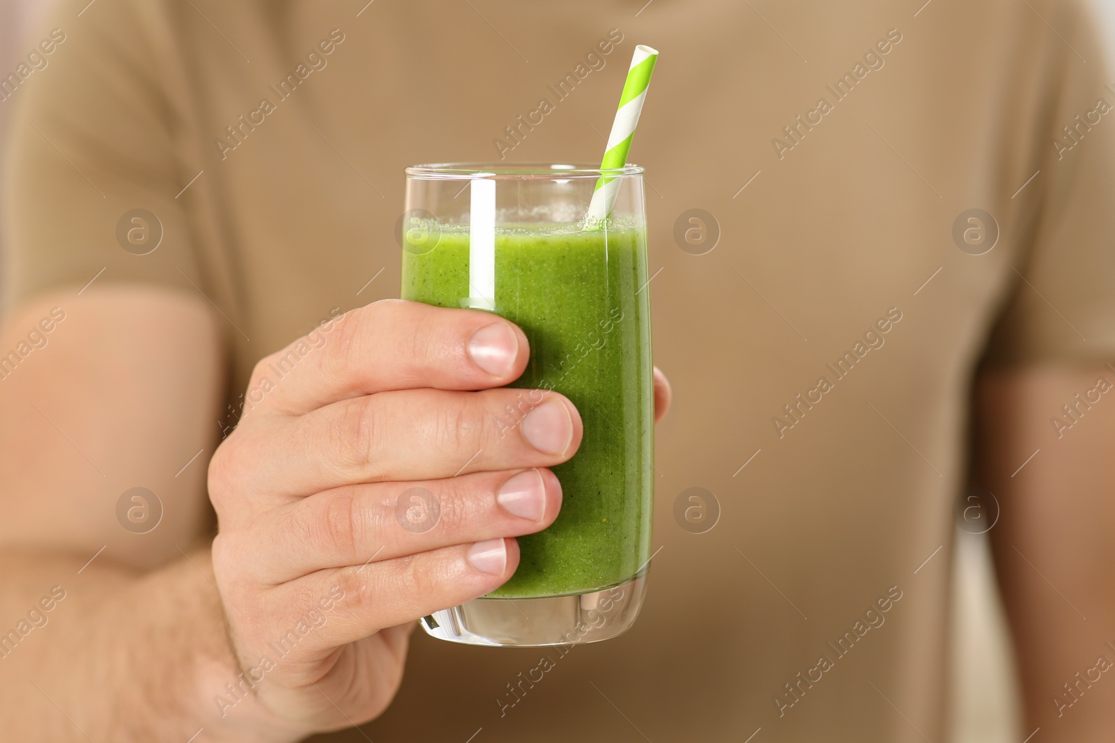 Photo of Man holding glass of delicious smoothie, closeup