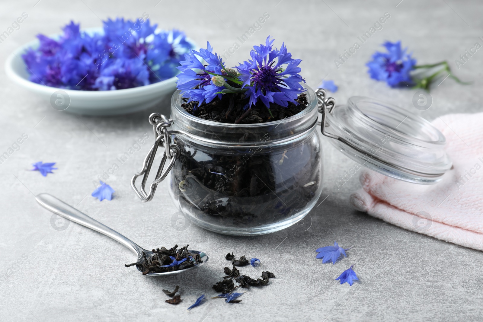 Photo of Dry tea leaves and cornflowers on light table