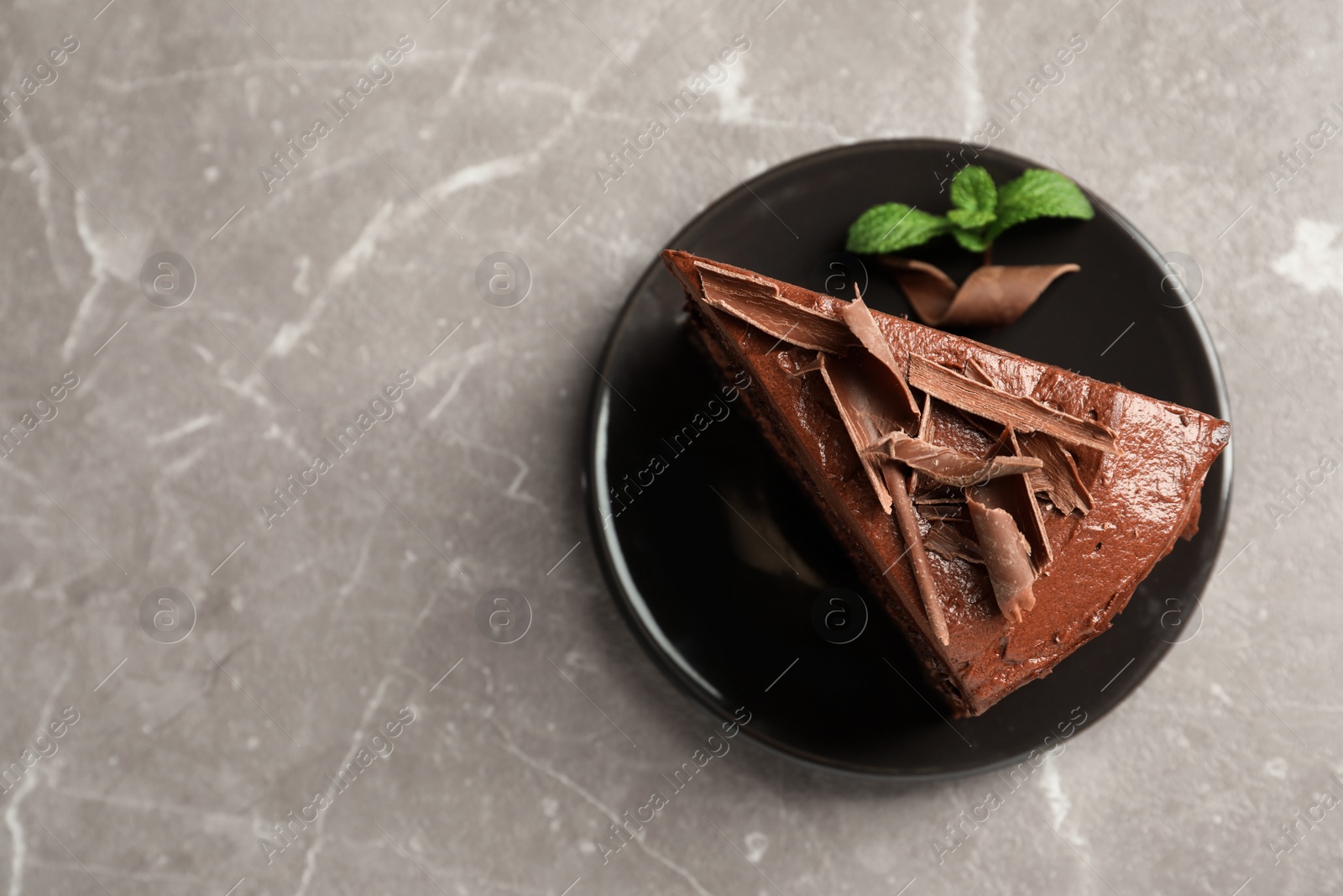 Photo of Plate with slice of tasty homemade chocolate cake and space for text on table, top view