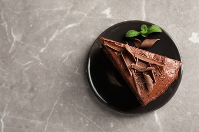 Plate with slice of tasty homemade chocolate cake and space for text on table, top view