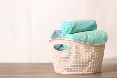 Basket with clean towels on table. Space for text