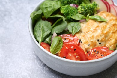 Photo of Healthy meal. Delicious chicken, vegetables and spinach in bowl on light grey table, closeup. Space for text