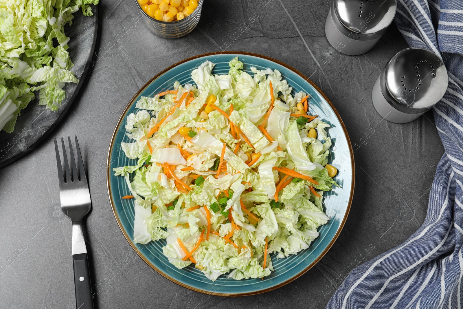 Photo of Fresh cabbage salad with carrot served on grey table, flat lay