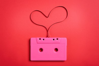 Photo of Music cassette and heart made with tape on red background, top view. Listening love song