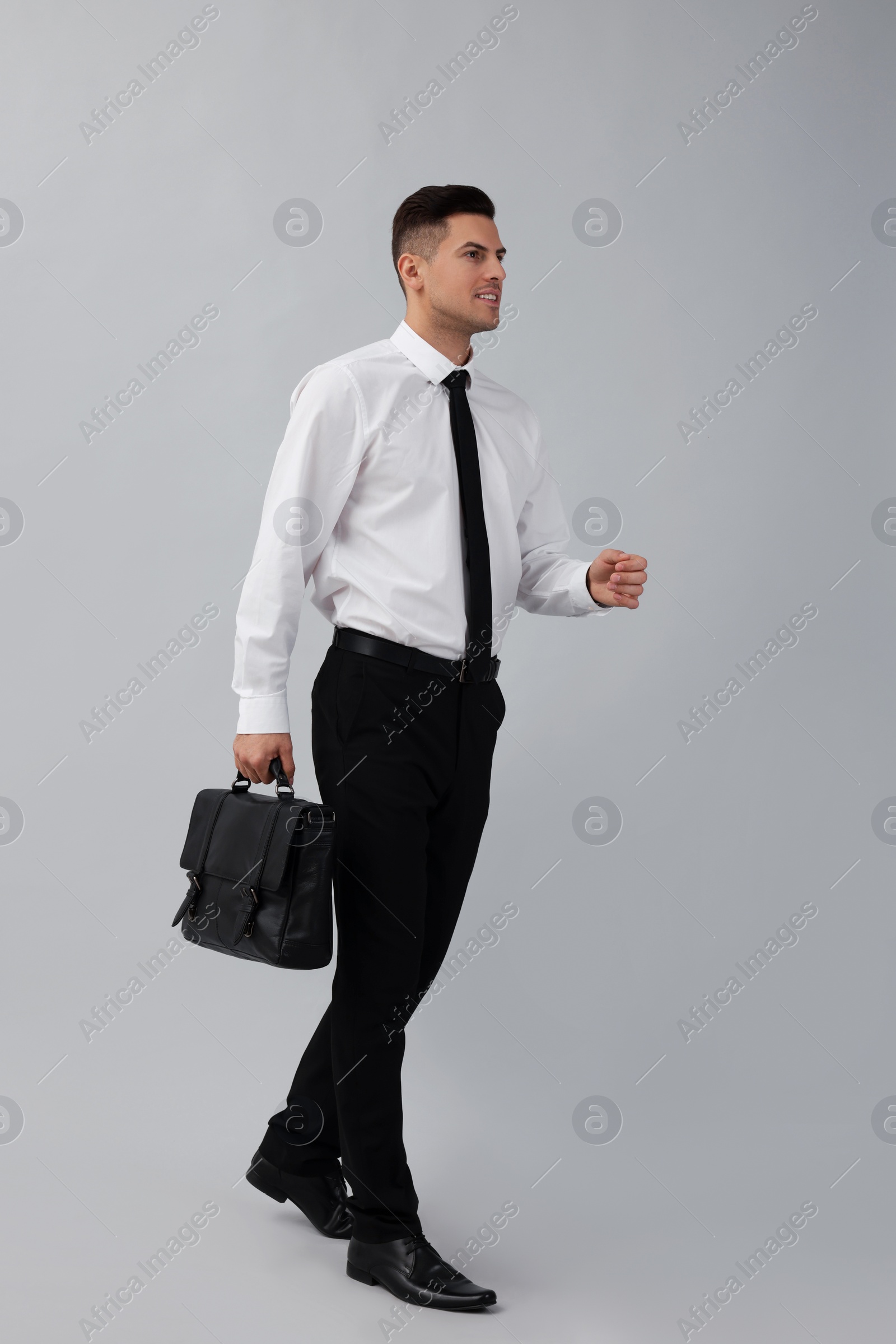 Photo of Businessman with stylish leather briefcase on light background