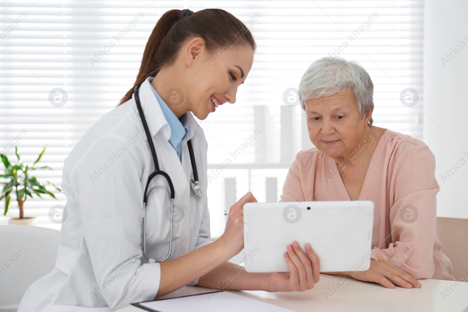 Photo of Senior woman visiting doctor in modern office