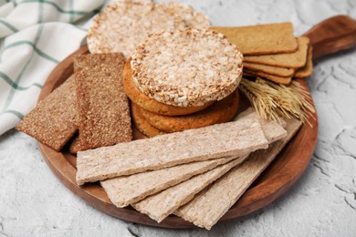 Photo of Rye crispbreads, rice cakes and rusks on white textured table