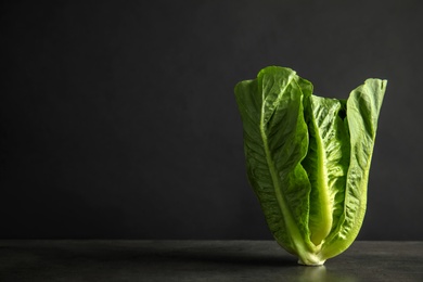 Photo of Fresh ripe cos lettuce on table in darkness