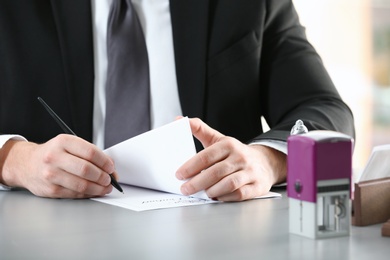 Male notary working with documents at table, closeup