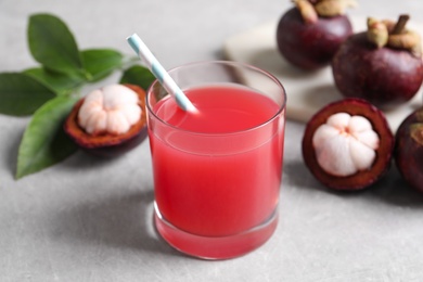 Delicious mangosteen juice in glass on light table